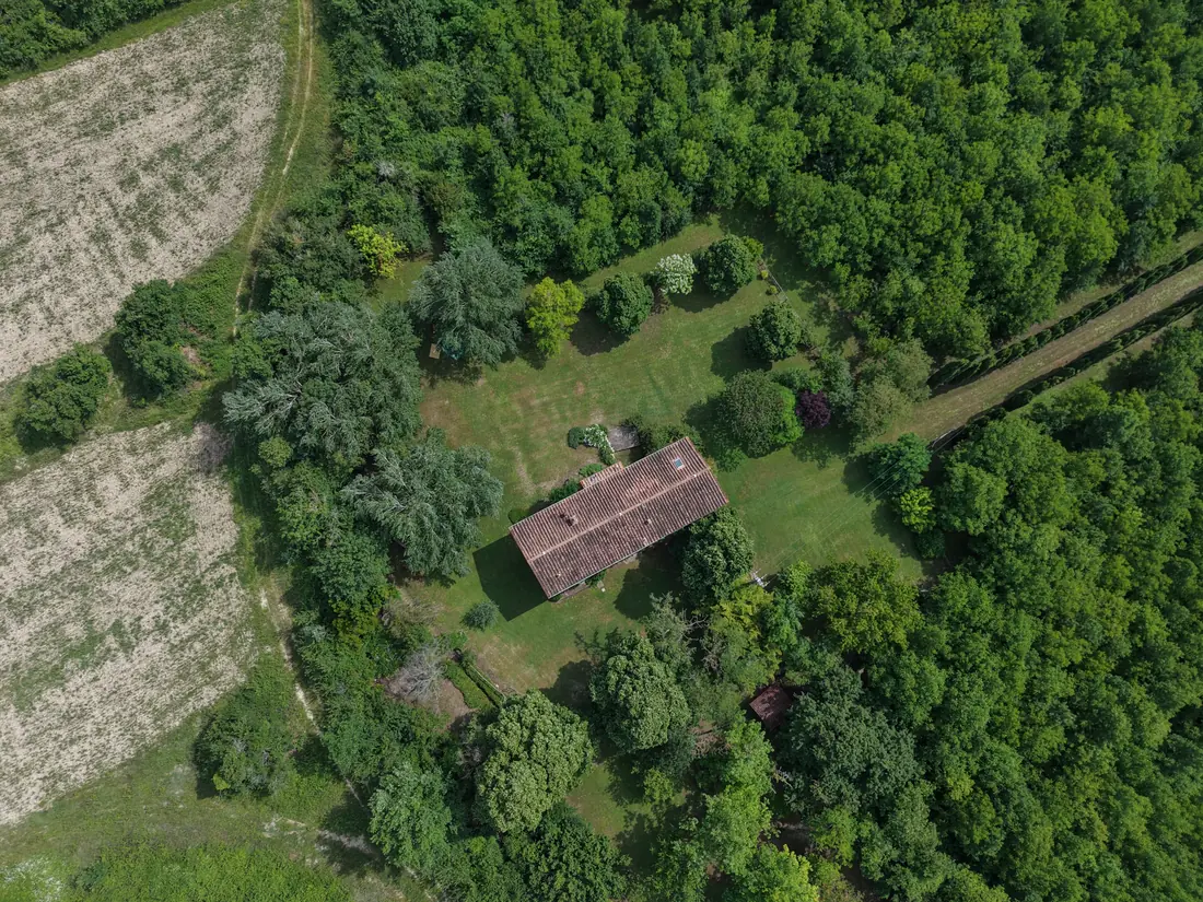 Casale in pietra immerso nel verde visto in verticale dal drone, campagna toscana