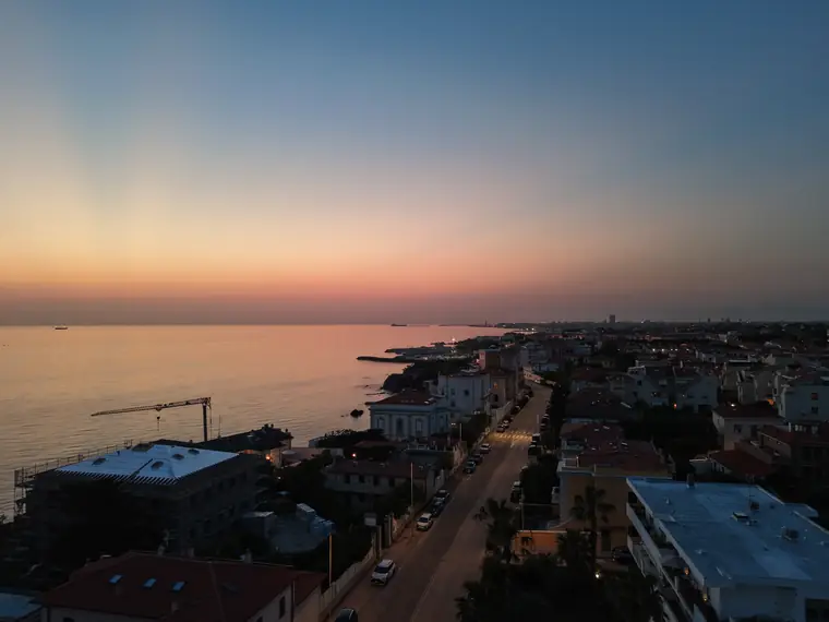 Ultimo sole sul mare e tetti in controluce, foto aerea